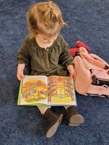  Child reading a book at a Daycare Program with Focus on Montessori and STEM 