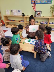 students around a teacher at a Montessori campus